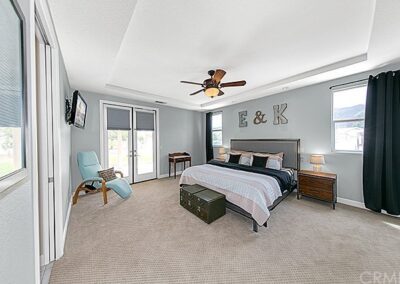 A bedroom with a ceiling fan.